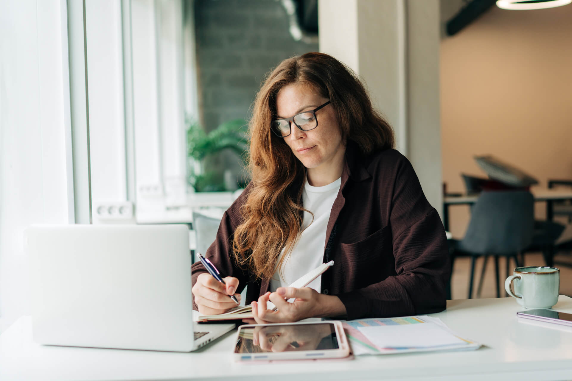 Gründerin arbeitet am Laptop an ihrem Businessplan und Antrag